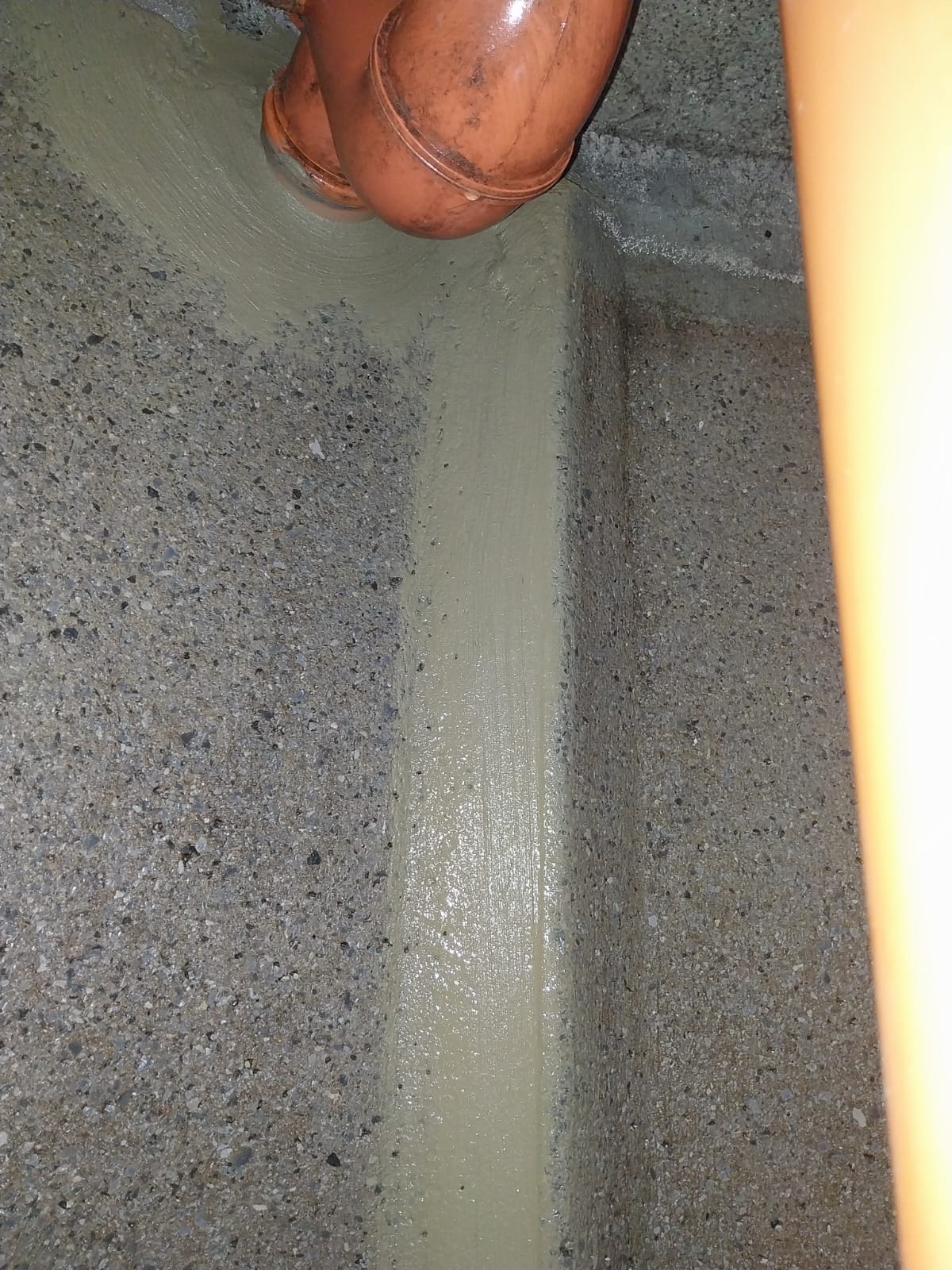 Raccord PVC en coude scellé au mortier
